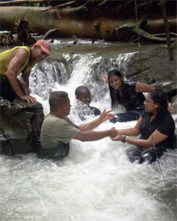 Hikeseekersassisting hikers in a dip in the waterfall